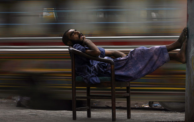 24 hours : A heroin addict sleeps on a chair at a bus stop in Karachi