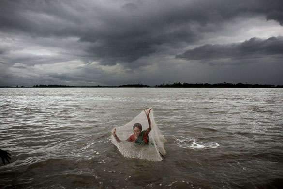 Bangladesh flood defences: Men and women fish along the embarkment