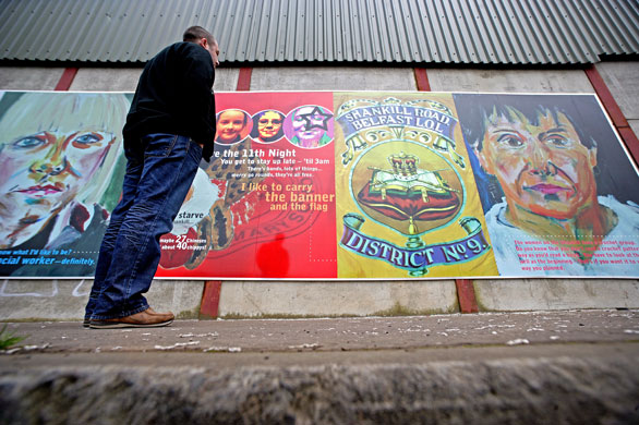 Peace walls in Belfast: A man looks at one of three murals on the loyalist side of the peaceline