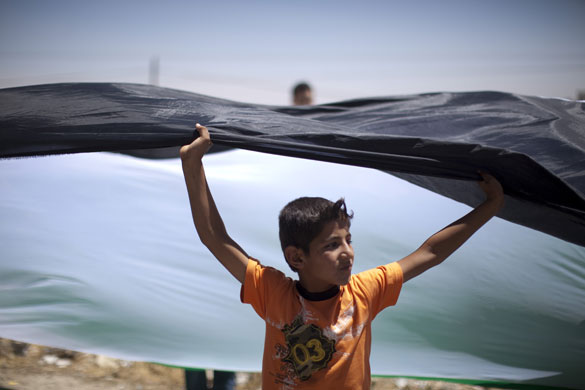 24 hours in pictures: A Palestinian boy holds his country's flag during a demonstration