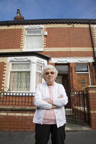 Manchester East 1 - 10: An elderly woman stands outside her home