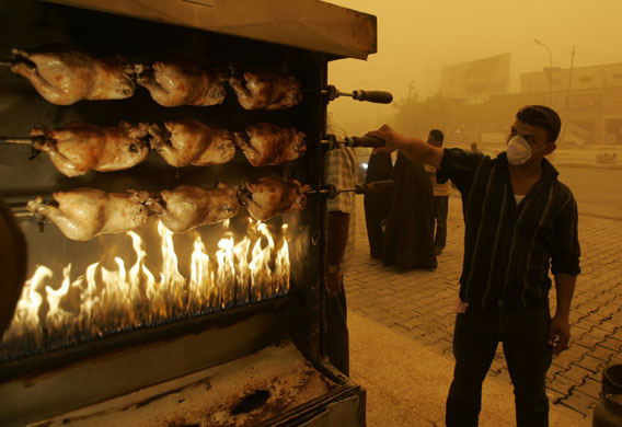 24 hours in pictures: A worker roasts chickens during a sandstorm in Baghdad