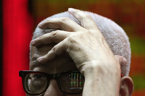 Week in Business: A man reads information at a brokerage house in Shanghai.