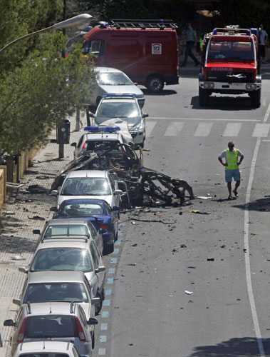 History of ETA: 30 July 2009: An investigator stands by the wreckage of a car in Palmanova