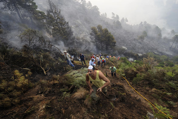 24 hours: El Arenal, Spain: Residents of  try to extinguish a wild fire 