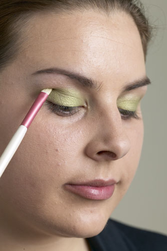 how to put on eye makeup. Pat on a bright green shadow
