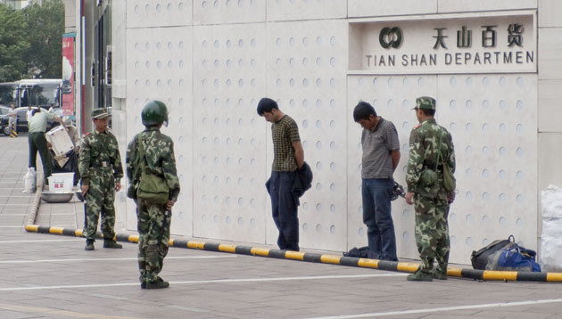 Urumqi riots: Uighurs are detained by security forces during a clampdown