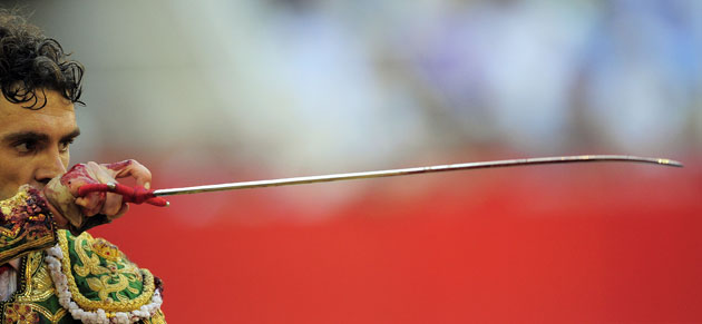 24 hours in pictures: Spanish bullfighter Jose Tomas holds up his sword before killing a bull  
