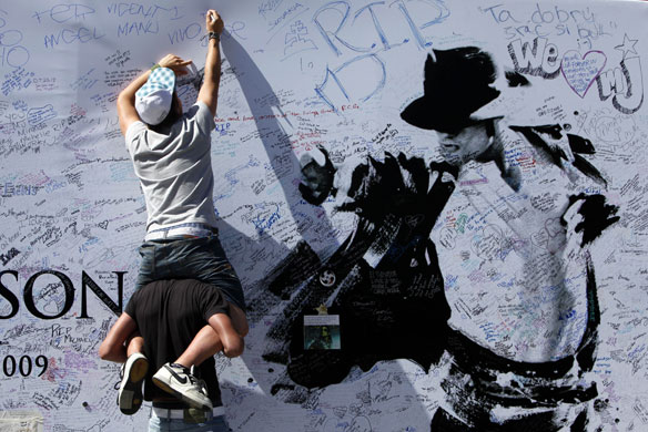 24 hours in pictures: Fans signs a large poster at the Staples Centre in LA for Michael Jackson