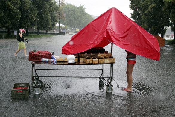 24 hours in pictures: Strawberry vendor stands in rain and flooded street of Warsaw, Poland