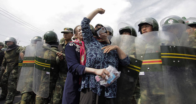 Uighurs protest: Protest by Uighurs against a line of security forces 