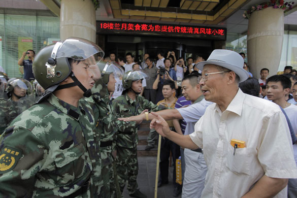 Urumqi riots: A vigilante old man argues with a People's Armed police officer