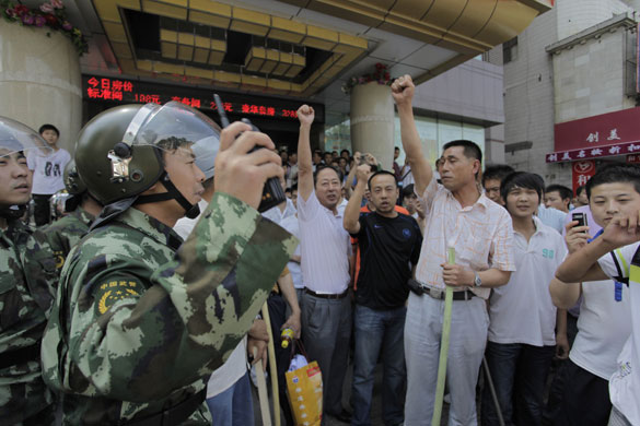 Urumqi riots: Armed police try to stop Han Chinese vigilantes taking to the streets