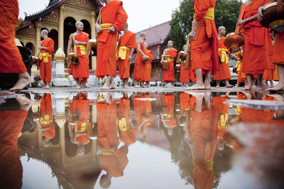 24 hours in pictures: Buddhist monks stand in the early morning rain Laos