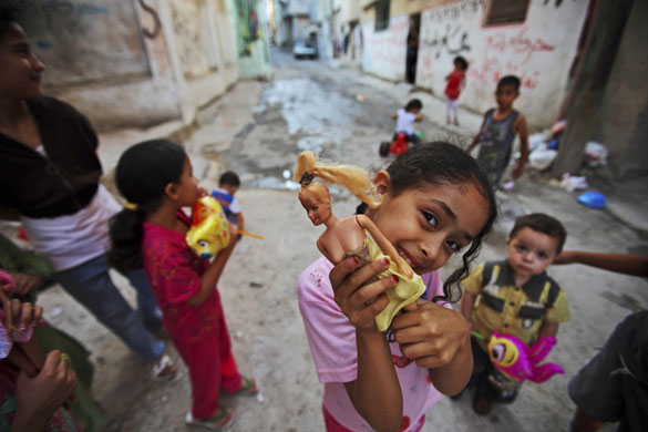 24 hours in pictures: A Palestinian girl holds up her doll