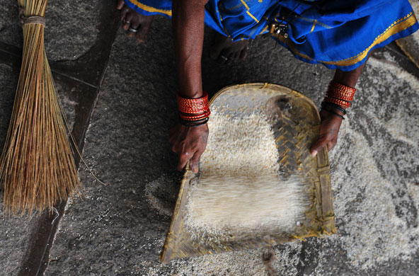 24 hours in pictures: An Indian labourer cleans spilt rice