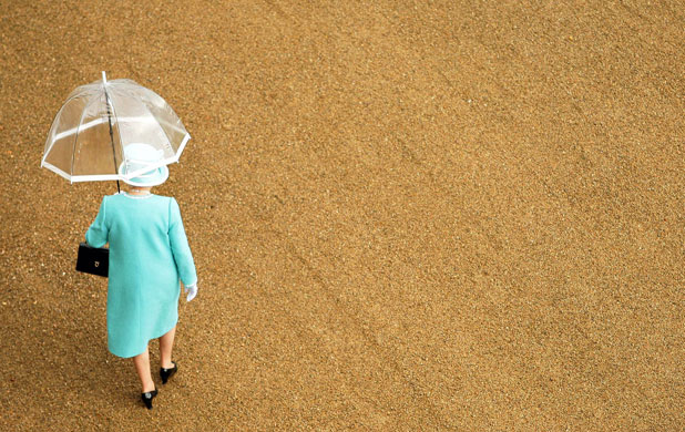 weather london: Queen Elizabeth shelters from the rain at Buckingham Palace 