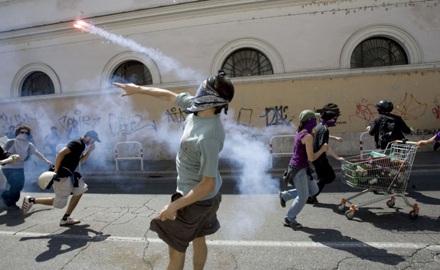 G8 preparations: A protester throws a flare towards Italian riot police in Rome
