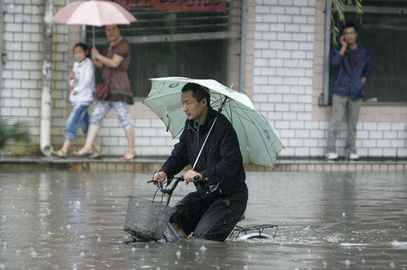 24 hours in pictures: A man rides a bicycle on a flooded street 