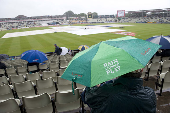 Toms Ashes Day 3: Fan sits under an umbrella at a rain sodden Edgbaston