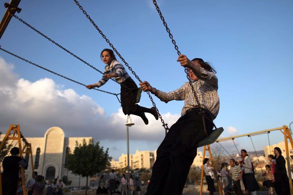 10 August 2009: Beitar Illit, West Bank: Ultra-Orthodox children play on swings