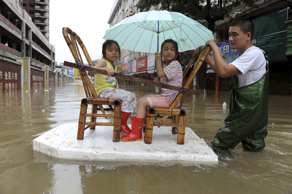 10 August 2009: Wenzhou, China: A resident pulls a makeshift raft
