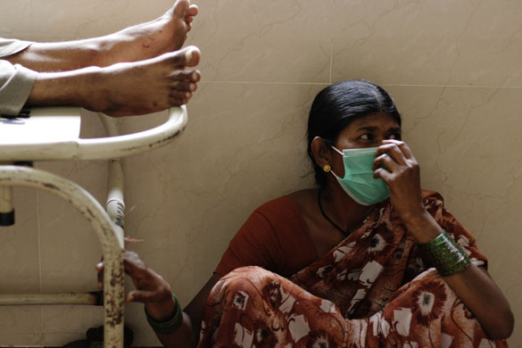 12 August 2009: Pune, India: A woman wears a surgical mask