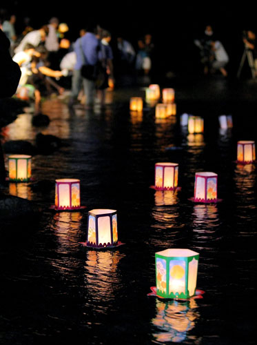 12 August 2009: Ueno, Japan: Candlelit paper lanterns float on the Kanna river