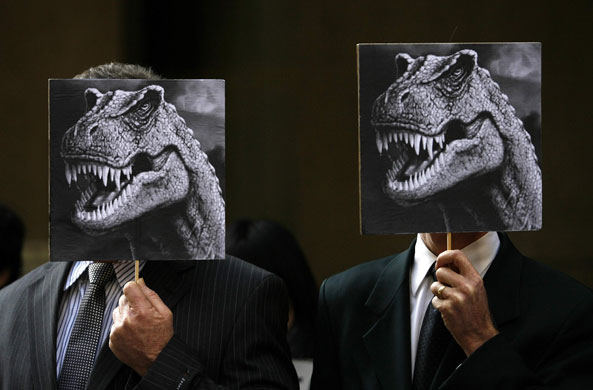 13 August 2009: Sydney, Australia: Two men hold pictures of dinosaurs during a protest