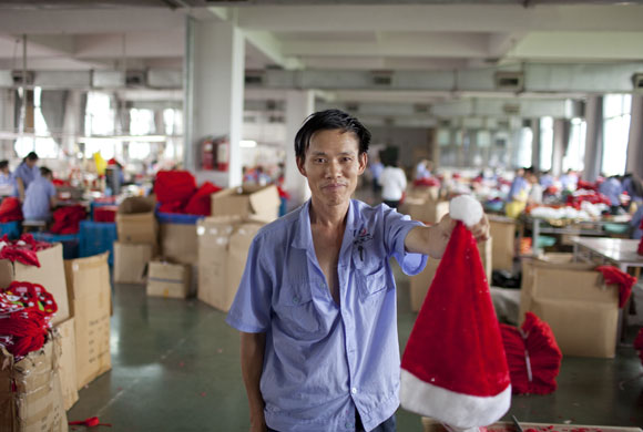 Christmas production line: A worker holds up a Santa hat from the production line in Yiwu 