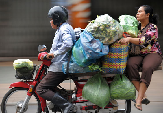 14 August 2009: Phnom Penh, Cambodia: A man rides his motorbike