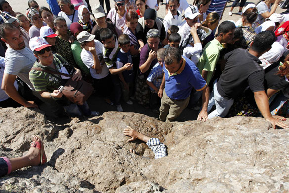 24 hours in pictures: Hacibektas, Turkey: An Alevi man tries to get out from a narrow cave