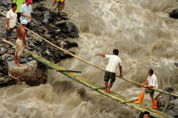 24 hours in pictures: Hsinfa, Taiwan: Stranded villagers use a makeshift bamboo bridge