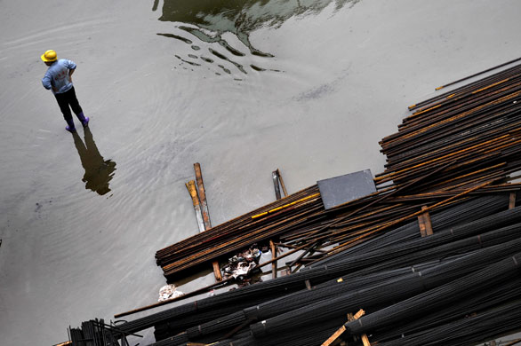 24 hours: Shanghai, China: A worker stands in a construction site 