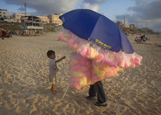 24 hours: Gaza City, Gaza: A Palestinian boy buys candy flossat the beach