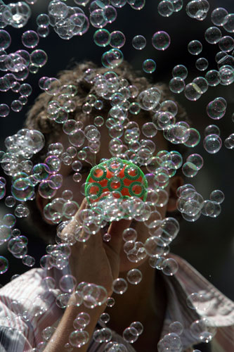 18 August 2009: Amman, Jordan: A boy with a bubble making machine