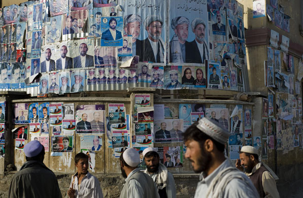 Afghanistan elections : Kabul: Afghans walk past a wall plastered with electoral posters 