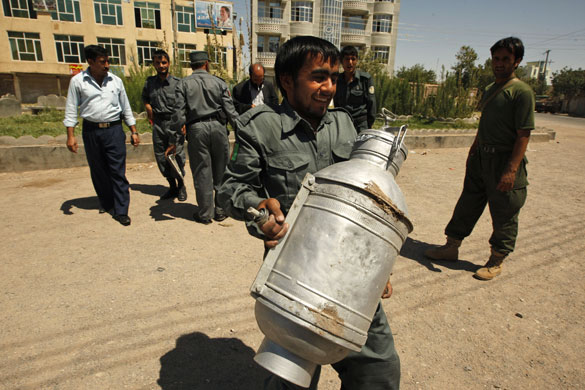 Afghanistan elections: Herat: policeman carries  diffused bomb after it was discovered on a street