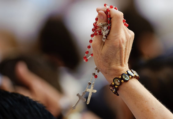 24 hours in pictures: Castelgandolfo, Italy: A pilgrim waves prayer beads to Pope Benedict XVI