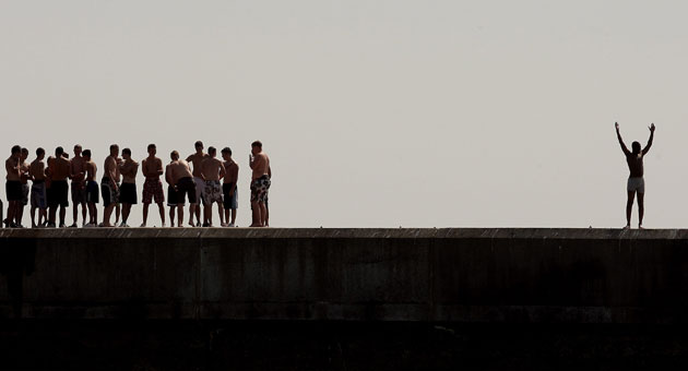 UK weather: A youth celebrates after jumping from a sea wall on in Hastings