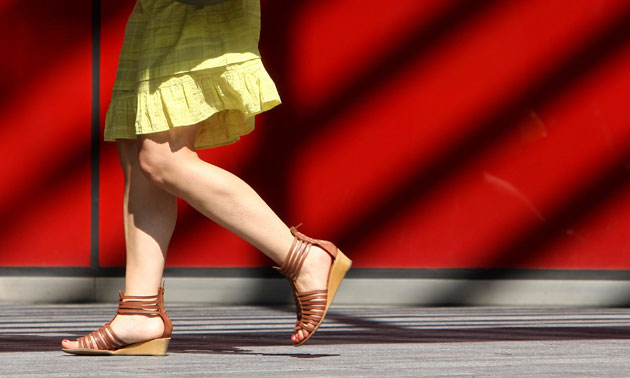 UK weather: An office worker in sandals walks in the sun near London Bridge in London