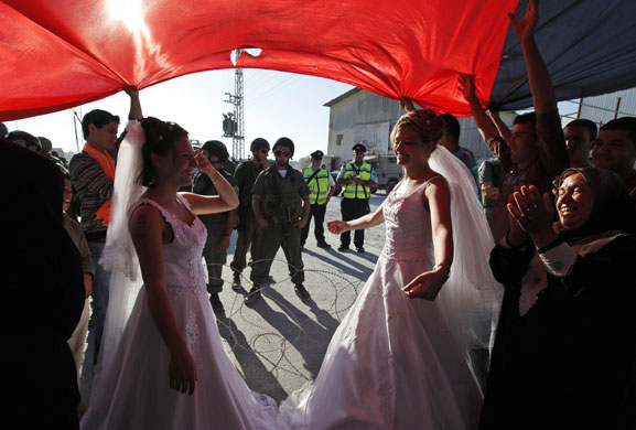 24 hours in pictures: Al-Masara, West Bank: Two Palestinian couples dance under a flag 