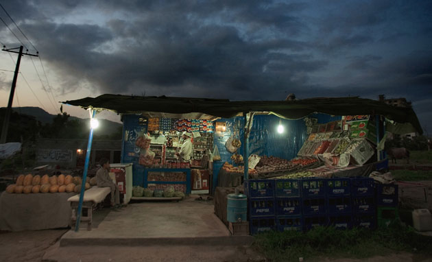 20 August 2009: Islamabad, Pakistan: A shopkeeper at his road side shop