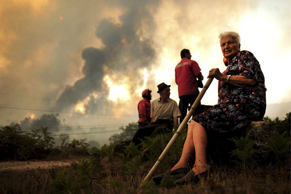 20 August 2009: Mangualde, Portugal: Local people watch the devastation of a forest fire