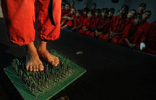 20 August 2009: Beit Lahia, Gaza Strip: A boy stands on nails during a training session