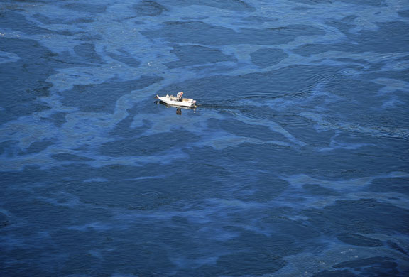 20 August 2009: Cheryomushky, Russia: A boat drives through oil polluted waters