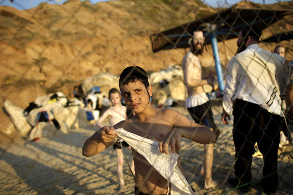 20 August 2009: Herzliya, Israel: An Ultra-Orthodox Jewish boy puts on his talit