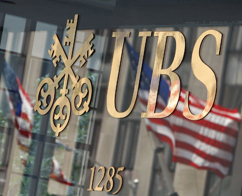 Week in business: U.S. flag is seen in a reflection outside the Swiss bank UBS offices
