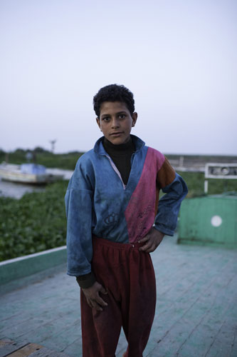 Nile Delta: A young child who works on the fishing boats on Lake Burullus