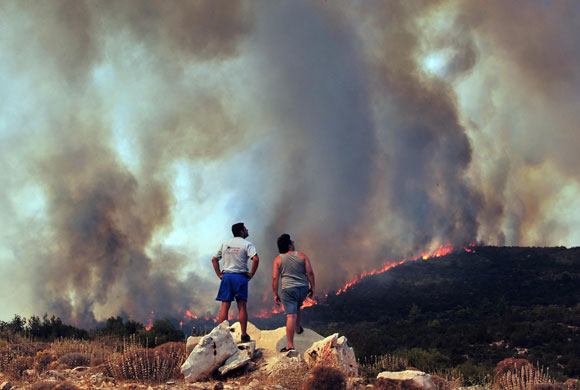 23 August 2009: Marathon, Greece: Locals watch a wildfire approaching